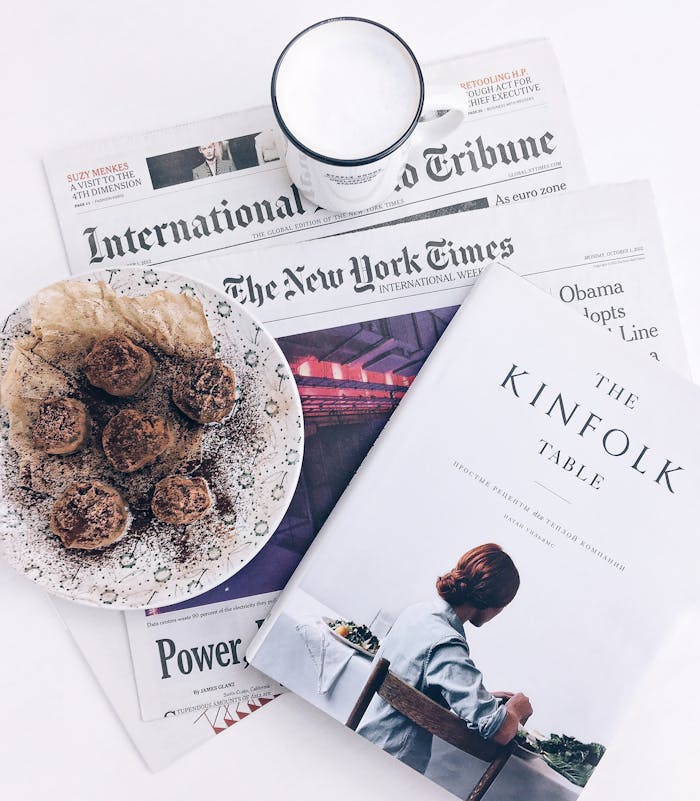 The Kinfolk Table Book Beside Baked Pastry on White Ceramic Plate With White Ceramic Mug